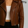 Close-up of women's vintage brown leather jacket — detailed stitching, zipper hardware, and natural leather grain texture