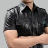 Left-side styled pose of a man wearing a genuine leather uniform shirt, showing the side profile, fitted silhouette, and epaulette strap detail