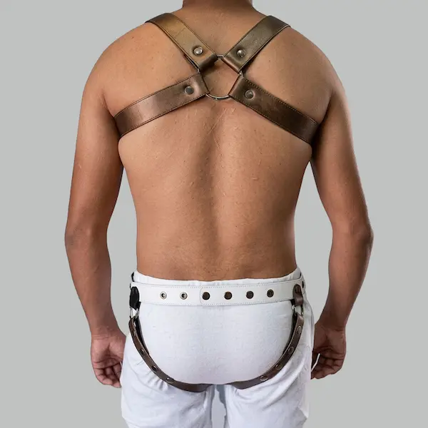 Back view of a men's leather chest harness showing strap crossover and metal hardware