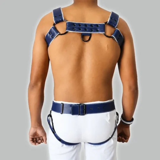Men's navy blue leather harness set back view, adjustable straps with buckle closure, studded chest strap, matching wrist band aur harness-style bottom.