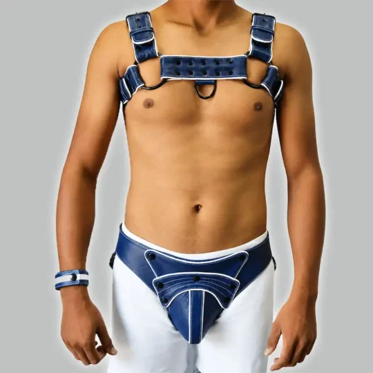 Navy blue aur white leather men's body harness set adjustable chest straps, studded detailing, matching wristband aur harness-style underwear.