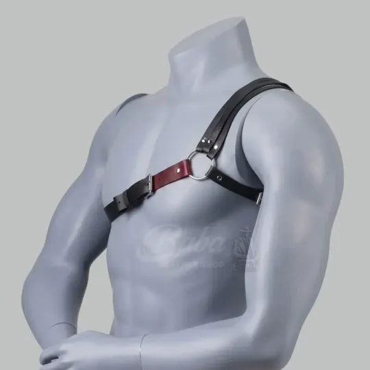 Side view of a Mens Leather Shoulder Harness displayed on a mannequin. The design features black and red leather straps, a front buckle, and a metal ring connecting the shoulder and chest straps.